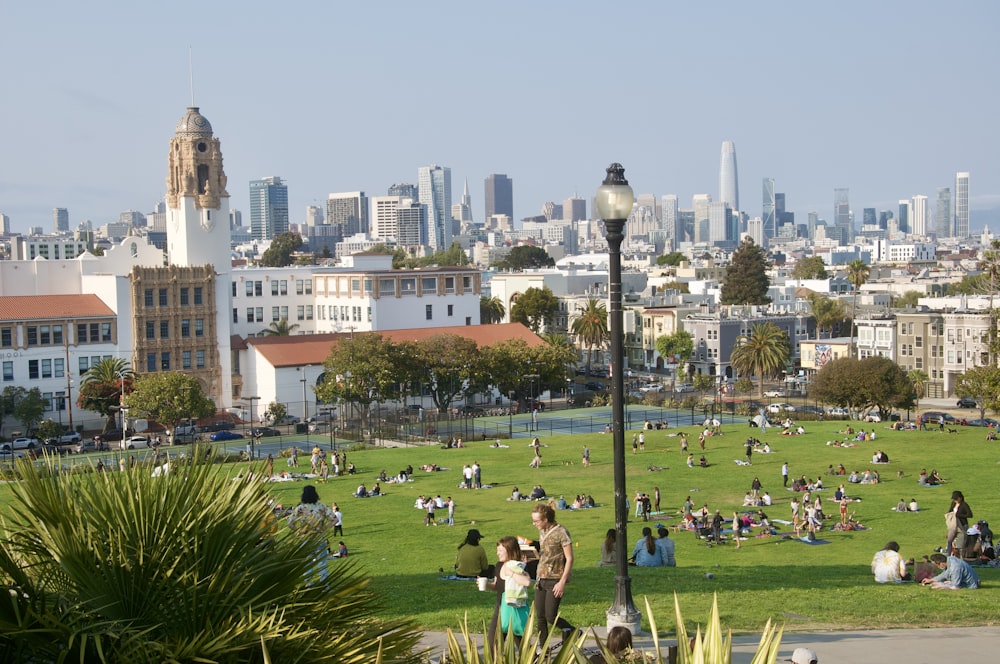 people on green grass field near white concrete building during daytime