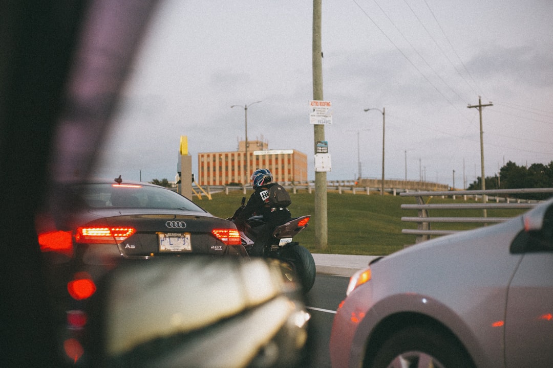 man in black motorcycle helmet riding motorcycle on road during daytime