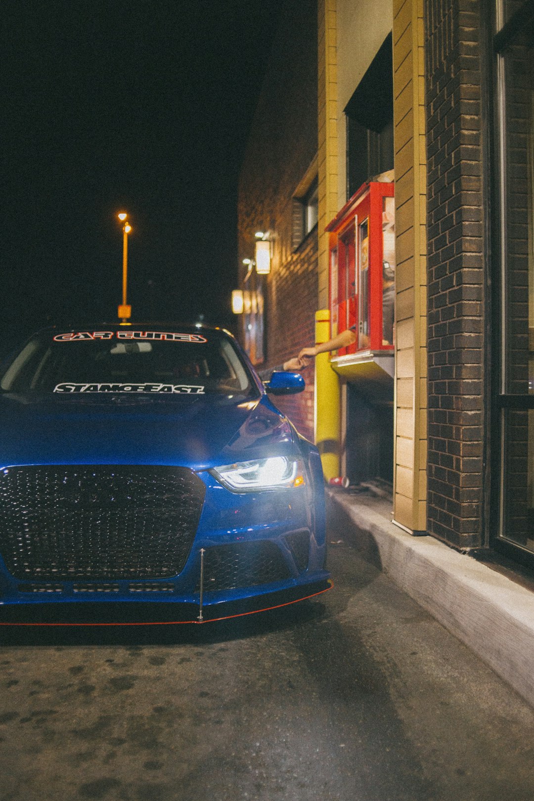 blue car parked beside building during night time