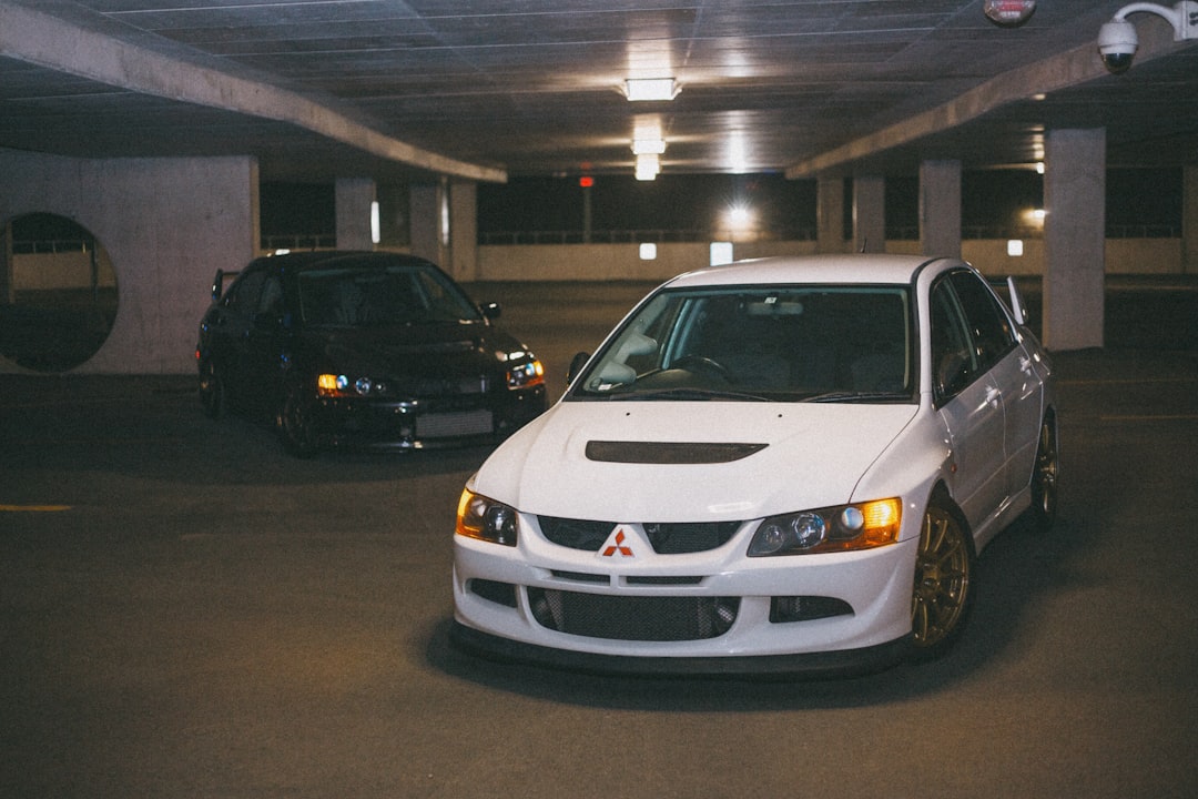 white honda car parked beside black car