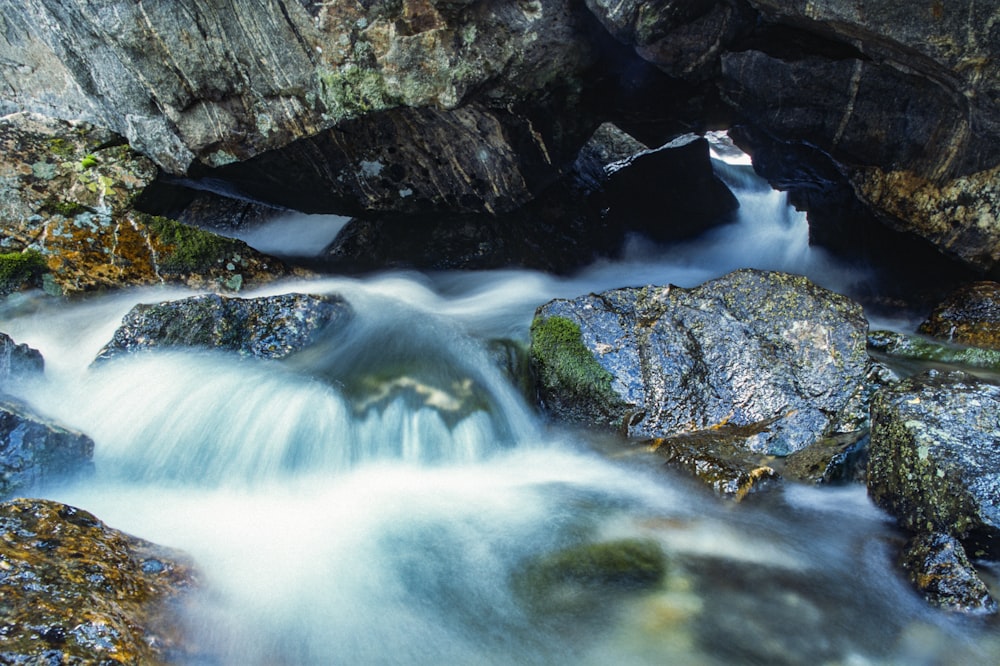 water falls on rocky mountain during daytime