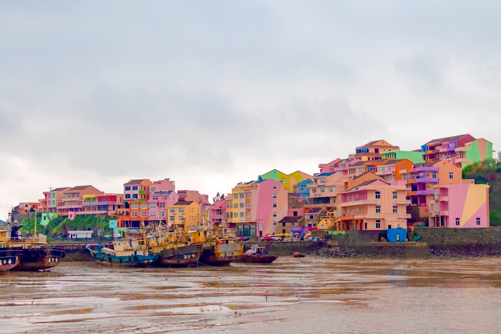 city buildings near body of water under cloudy sky during daytime