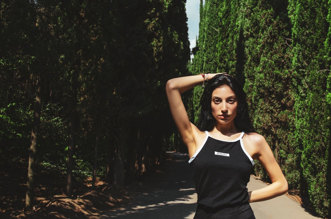 woman in black and white adidas tank top standing on road