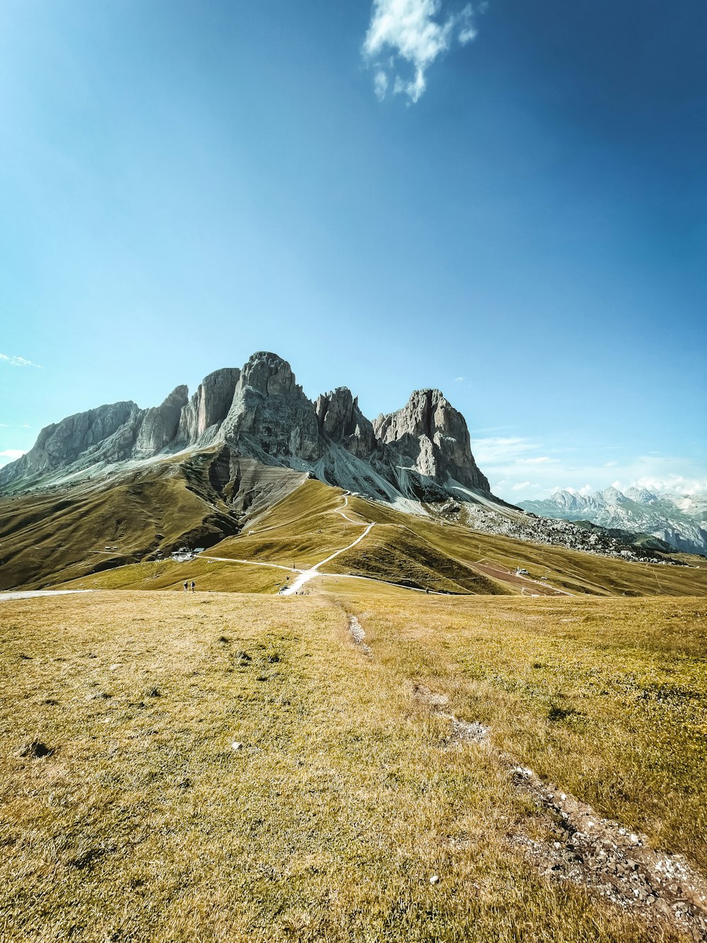 Grünes Grasfeld in der Nähe von Rocky Mountain unter blauem Himmel tagsüber