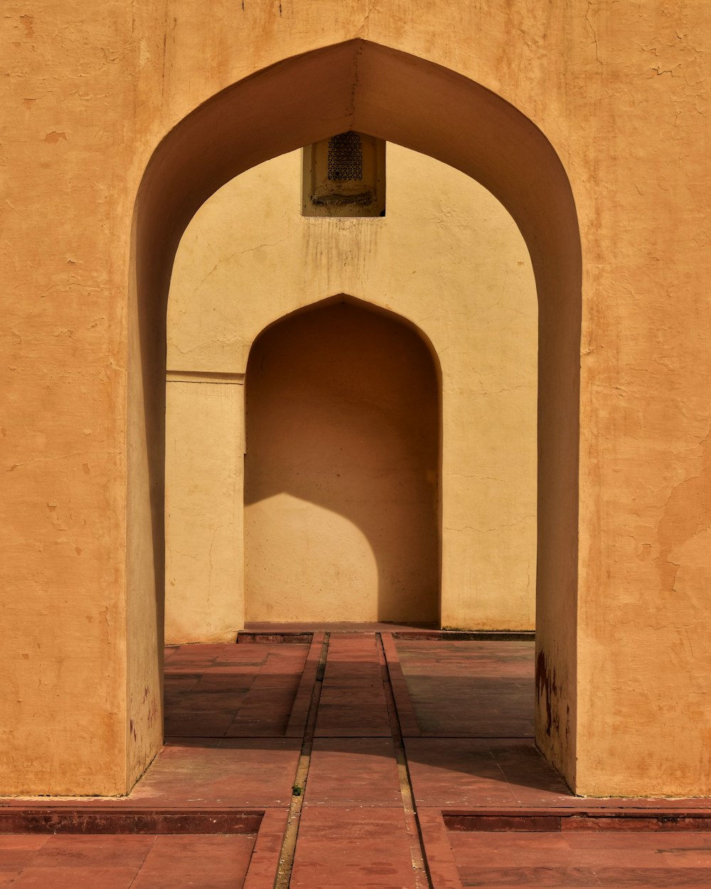 brown concrete building with arch shaped window