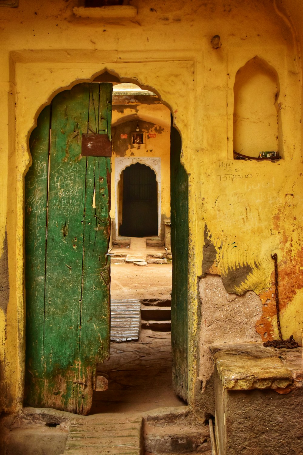 green wooden door with brown concrete wall