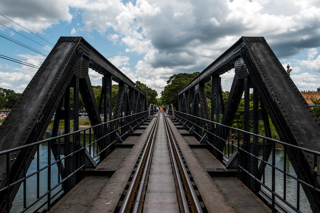 gray metal bridge under white clouds during daytime