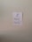 A simple piece of white paper is taped to a wall with two strips of white tape. The paper has a drawing of a musical note and the words 'Music Heals!' written in bold, black lettering.