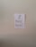 A simple piece of white paper is taped to a wall with two strips of white tape. The paper has a drawing of a musical note and the words 'Music Heals!' written in bold, black lettering.
