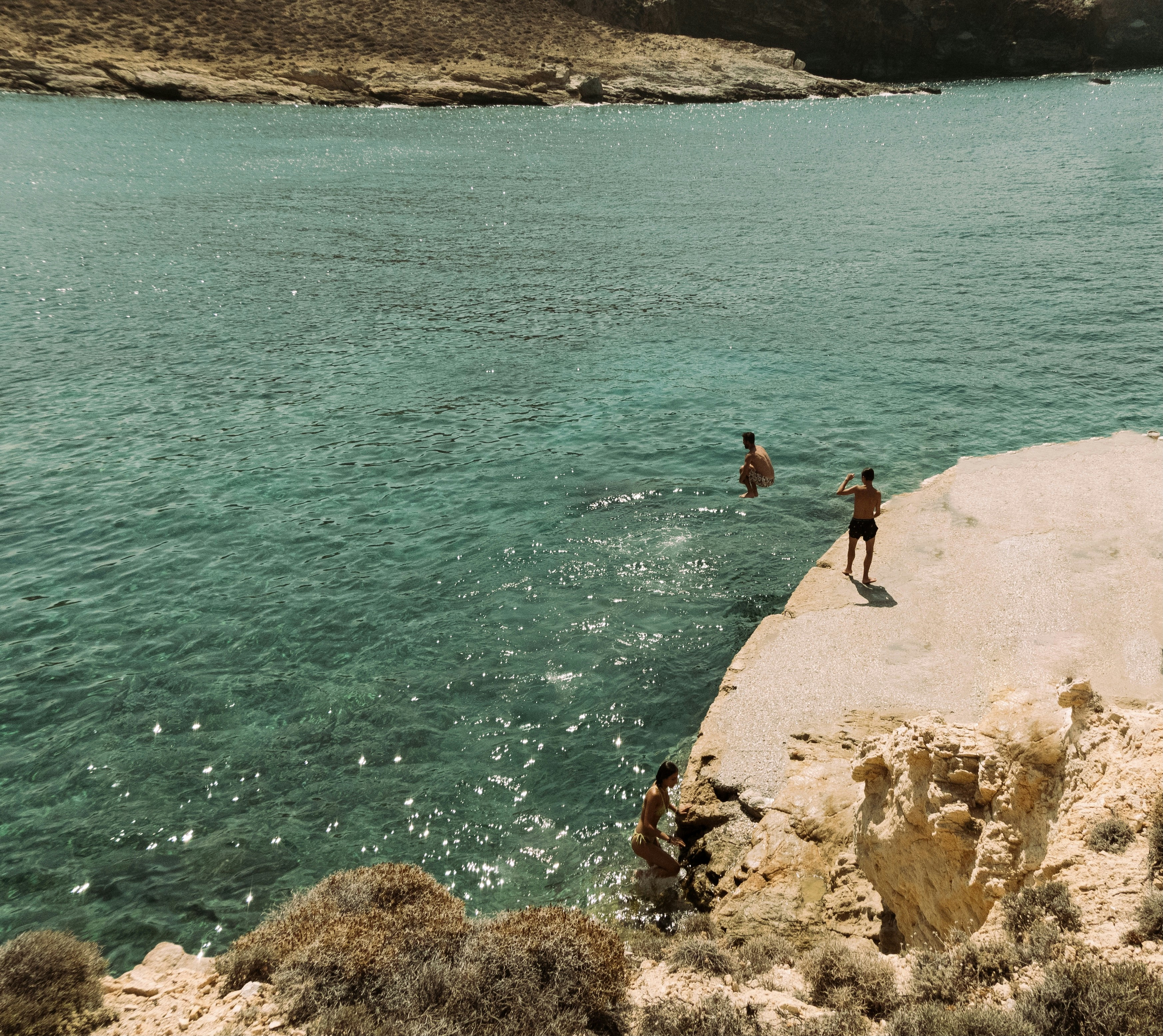 2 person standing on rock formation near body of water during daytime, Dive 