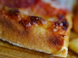 Close-up of a sizzling chicken tikka pizza with golden crust and bubbling cheese.