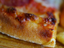 Close-up of a crispy, golden pizza fresh out of the oven with bubbling cheese.