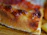 Close-up of a golden, thin crust pizza slice with bubbling cheese and fresh basil.