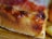 Close-up of a delicious pizza slice with melted cheese and fresh toppings.