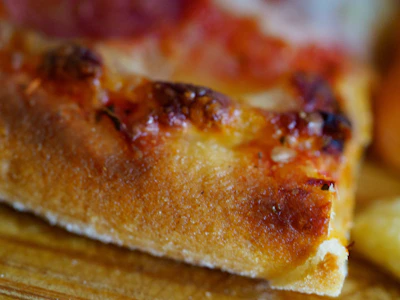 Close-up of a crispy, golden pizza fresh out of the oven with bubbling cheese.