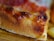 Close-up of a delicious pizza slice with melted cheese and fresh toppings.