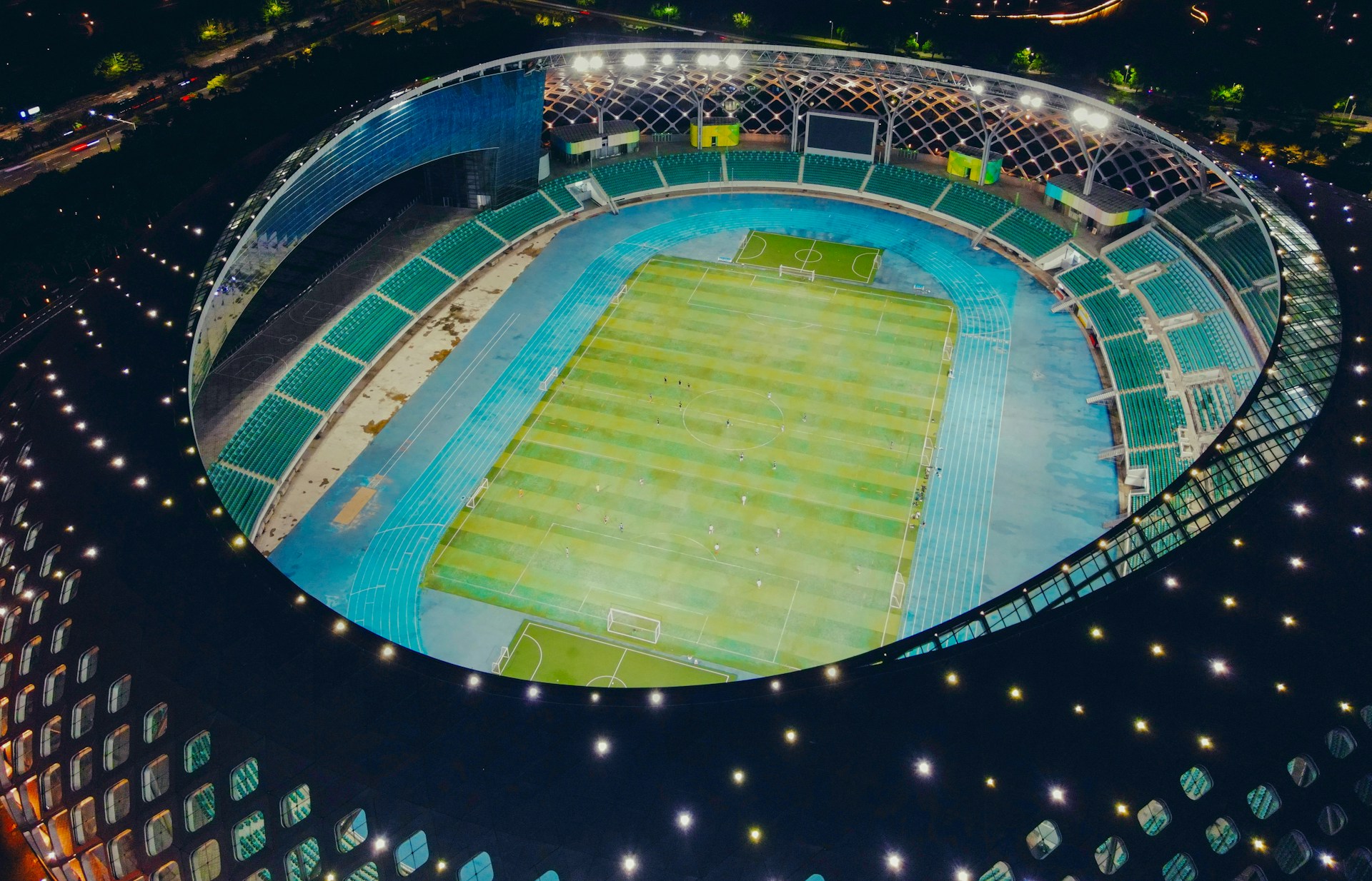 green and blue stadium with lights turned on during night time