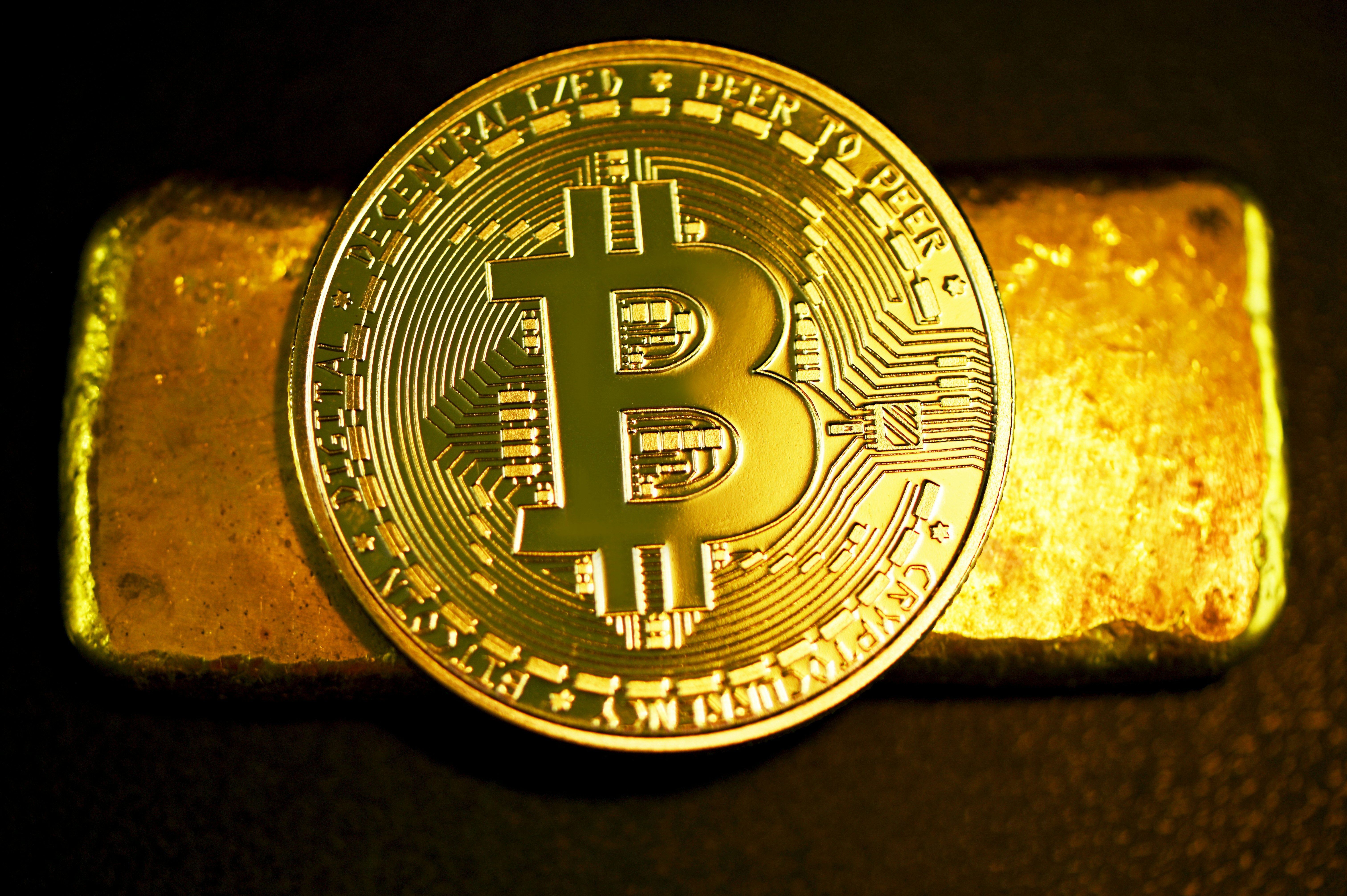 A single Bitcoin on top of a gold