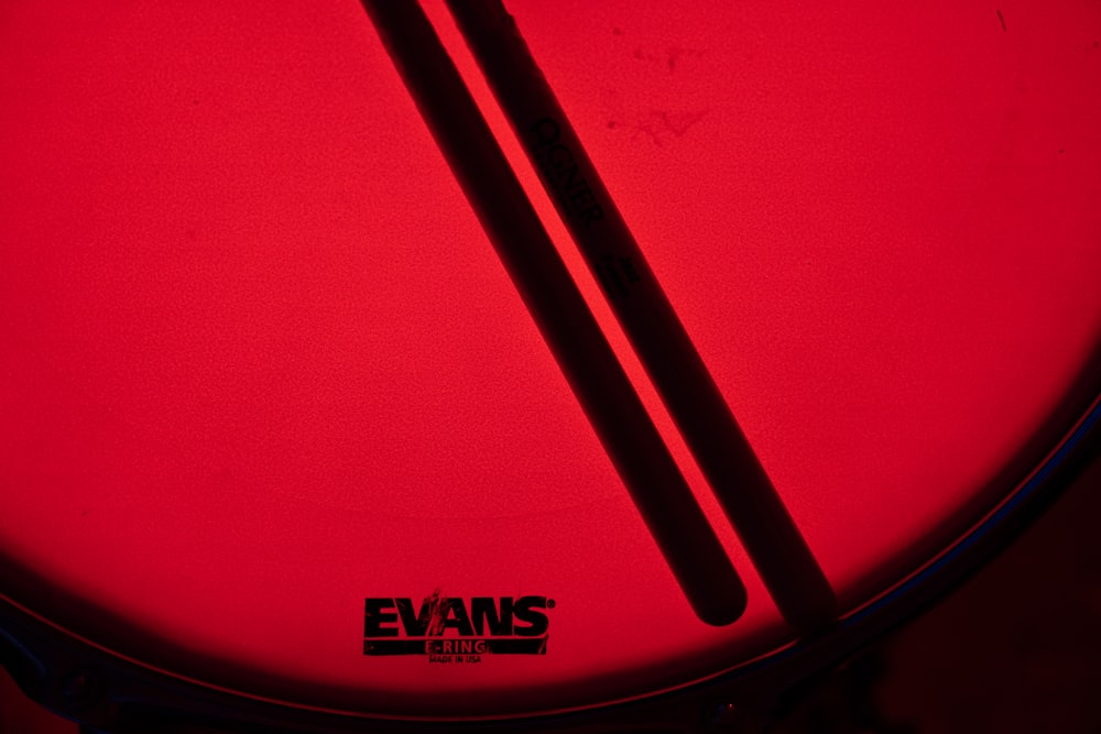 a close up of a drum head with a red background