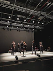 A joyful acting class in session with students practicing on stage