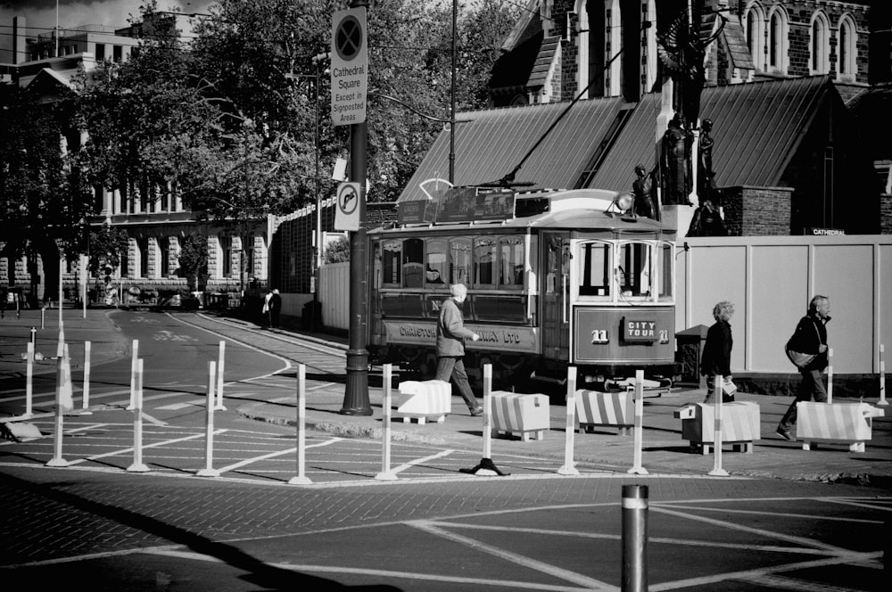 a black and white photo of a trolley on a street
