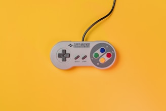 white nintendo game controller on yellow surface