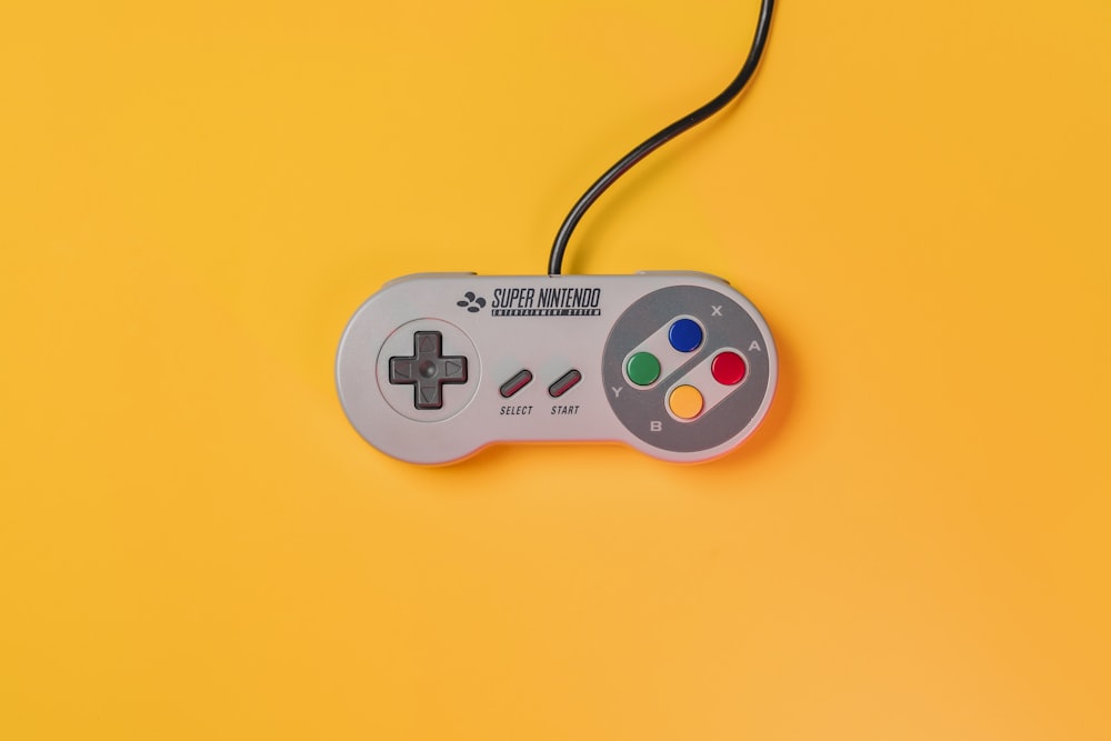 Controller di gioco Nintendo bianco su superficie gialla