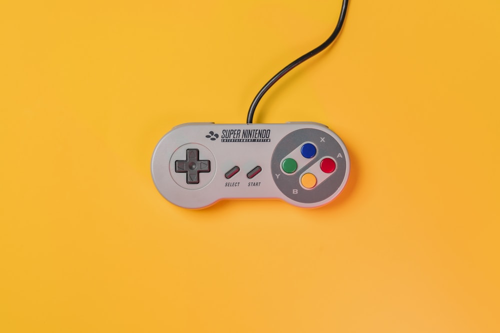 Manette de jeu Nintendo blanche sur surface jaune