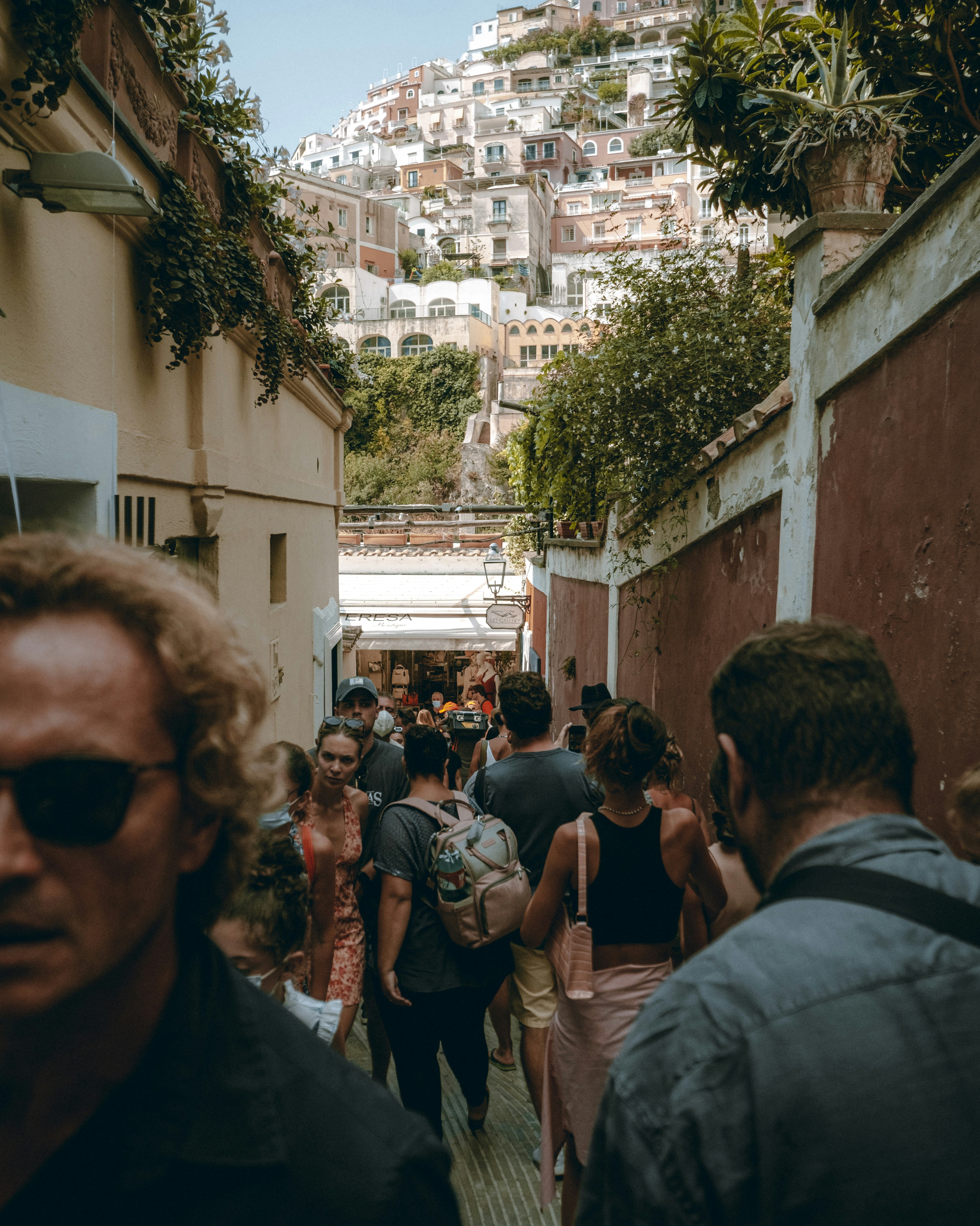 People walking along a sunlit Amalfi Coast street