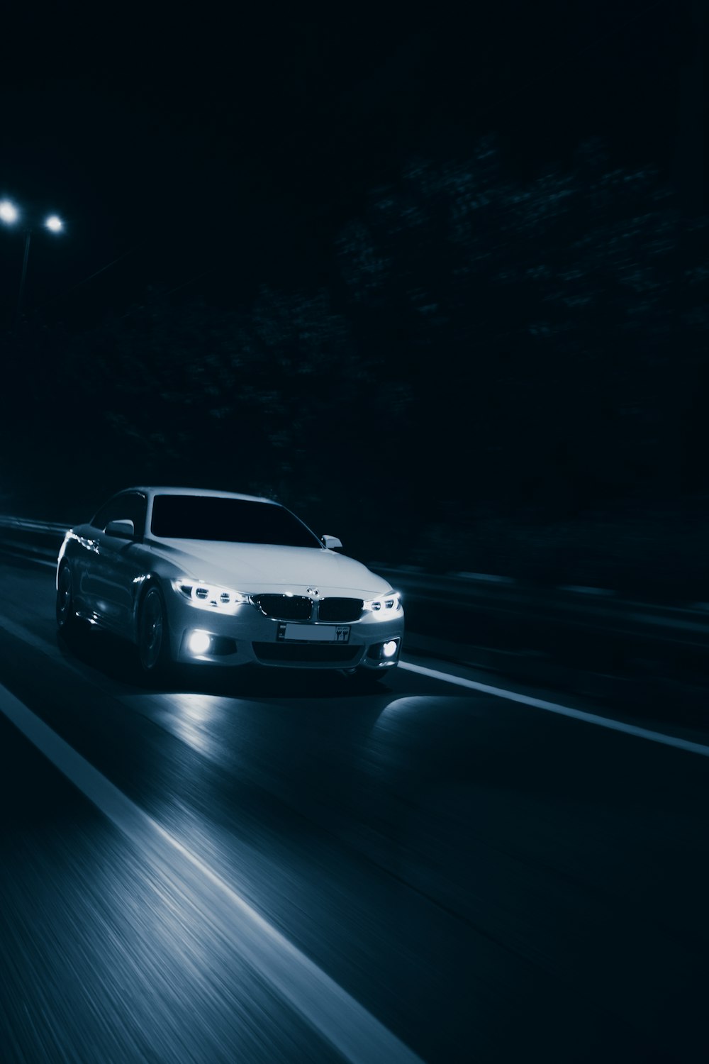 BMW M 3 blanche sur route pendant la nuit