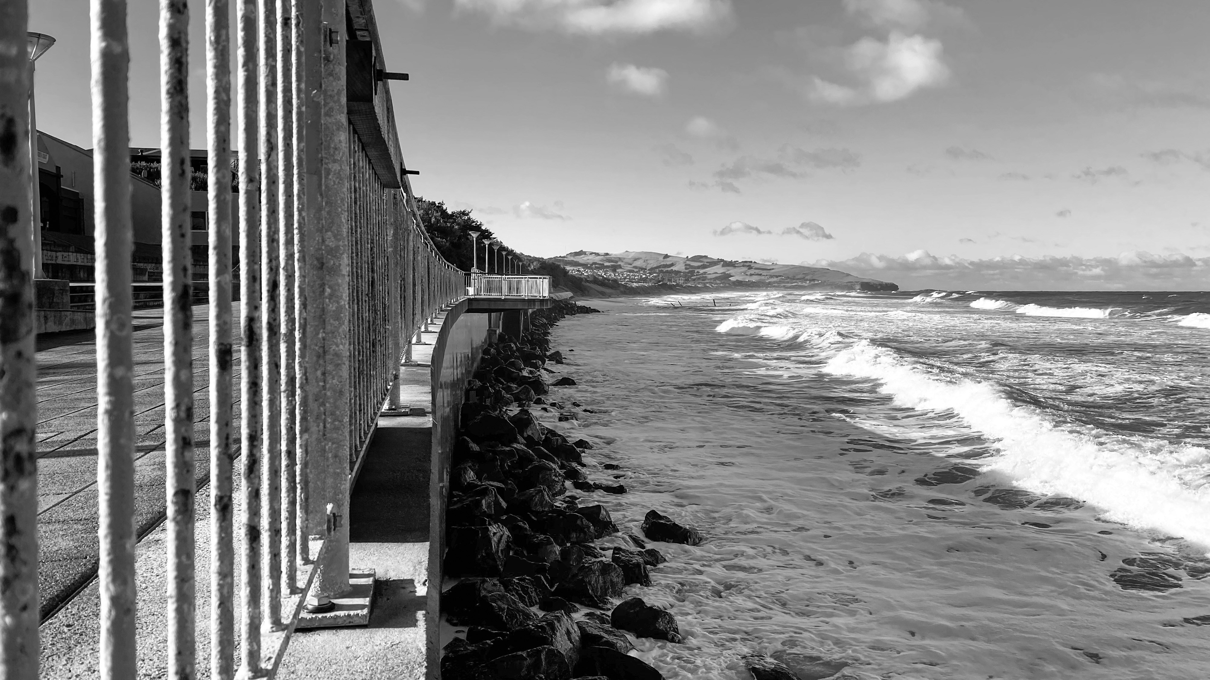 grayscale photo of wooden dock on beach