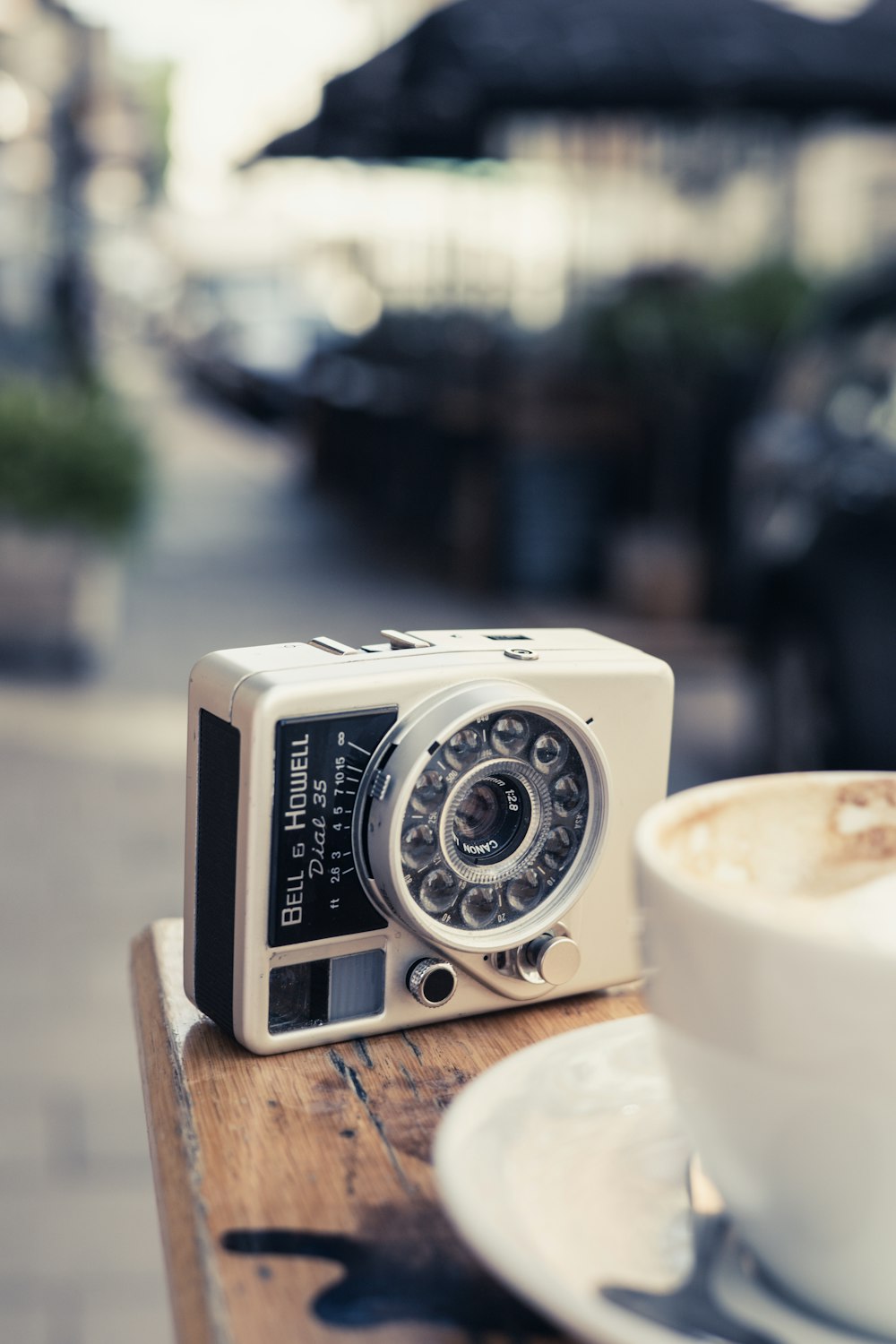 white and black point and shoot camera on brown wooden table