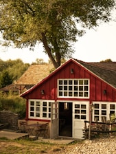red wooden house near green trees during daytime