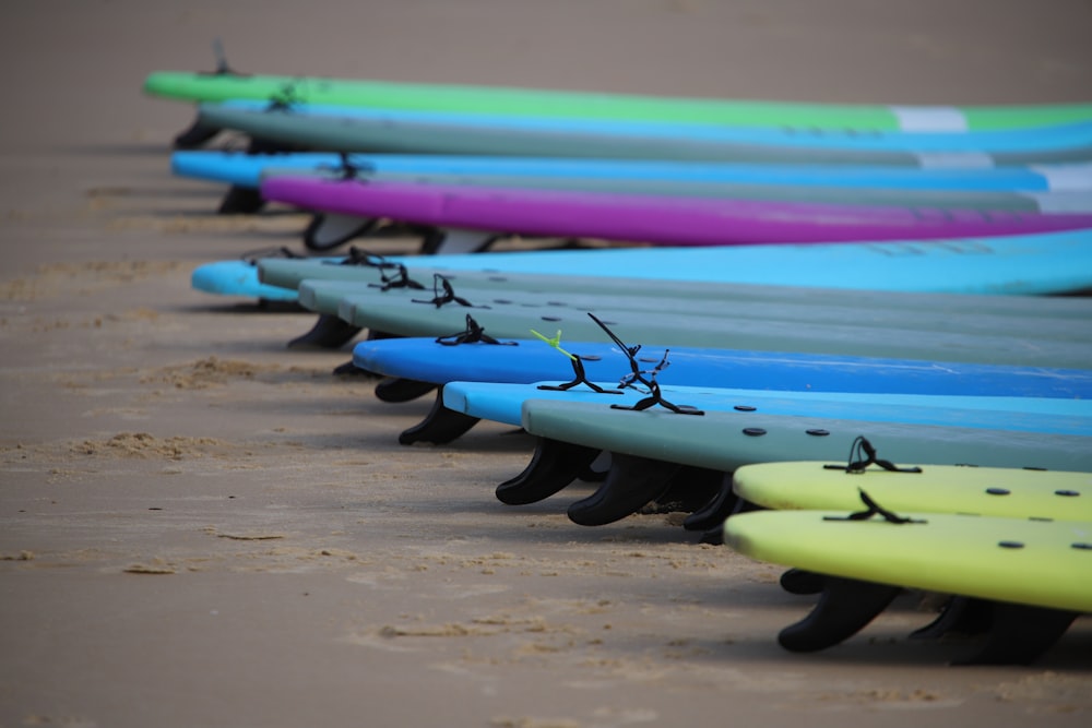 blue green and purple surfboard on beach shore during daytime