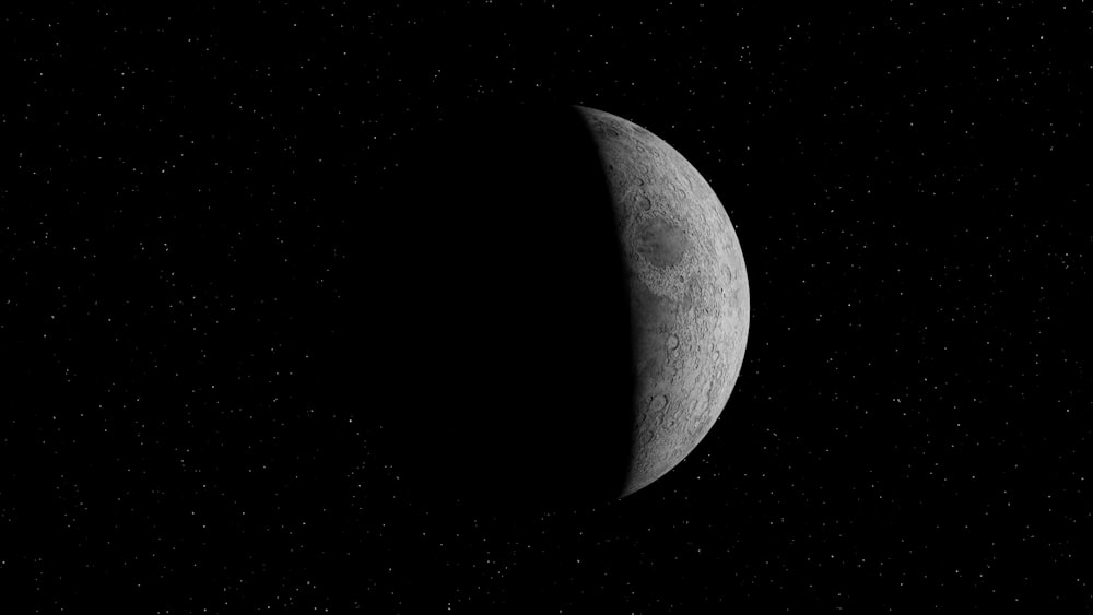 Photo en niveaux de gris de la lune dans le ciel nocturne sombre