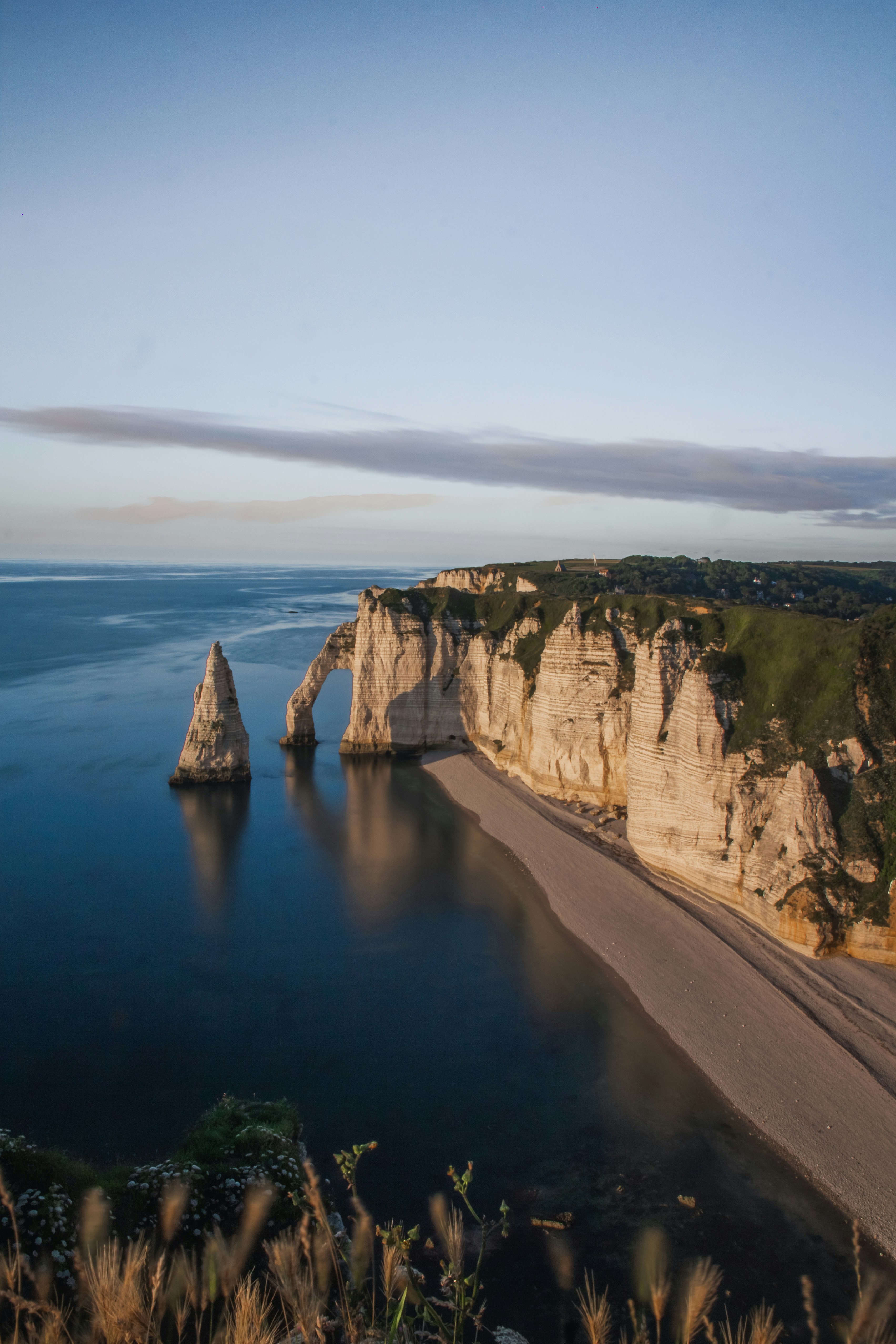 Brauner felsiger Berg neben blauem Meer unter blauem Himmel tagsüber
