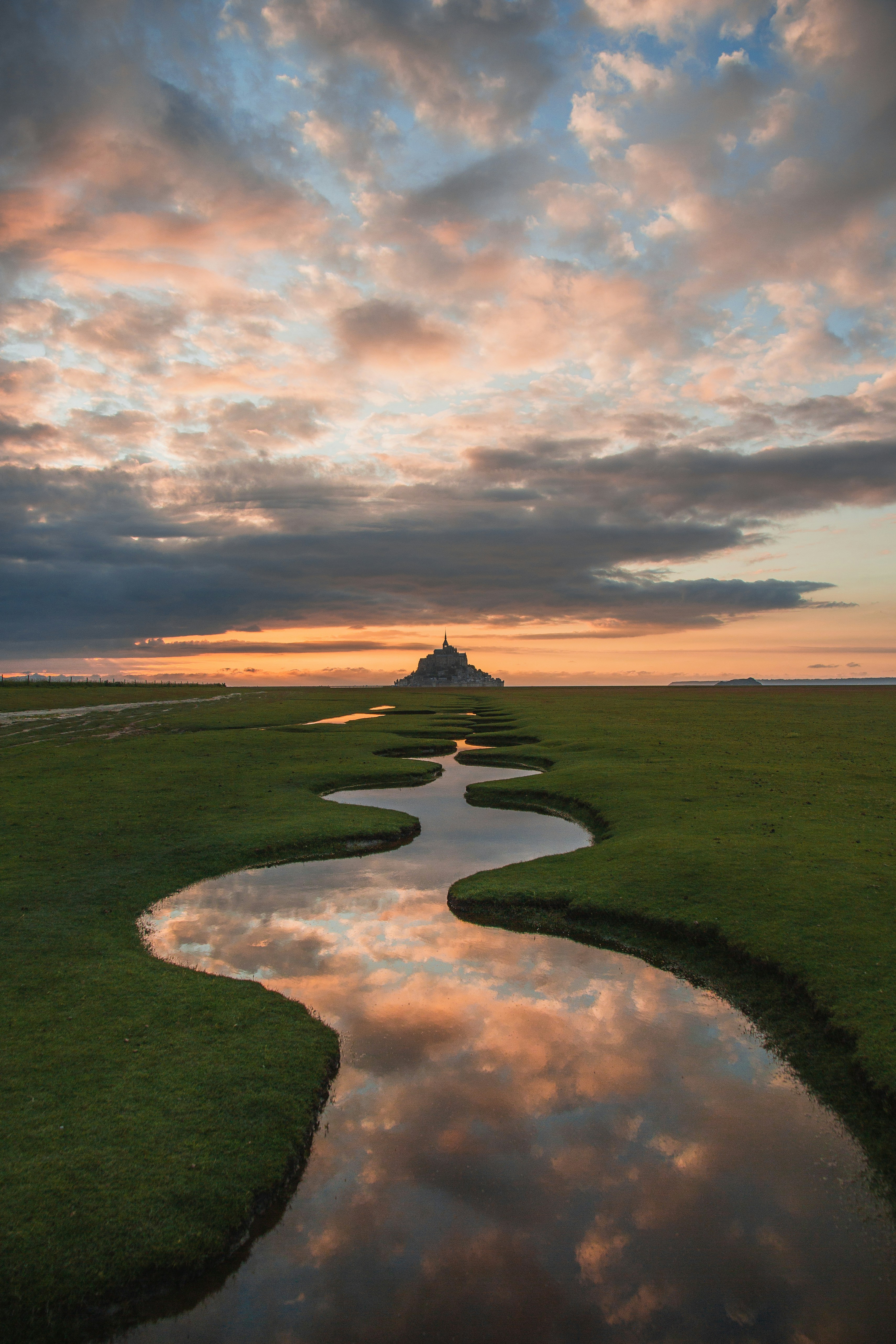 Grüne Rasenwiese unter bewölktem Himmel tagsüber
