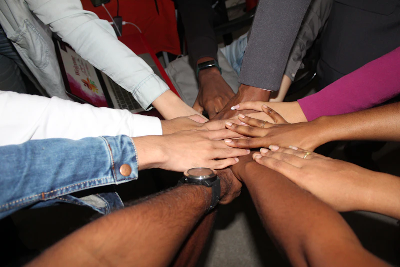 Small group placing hands together in unity