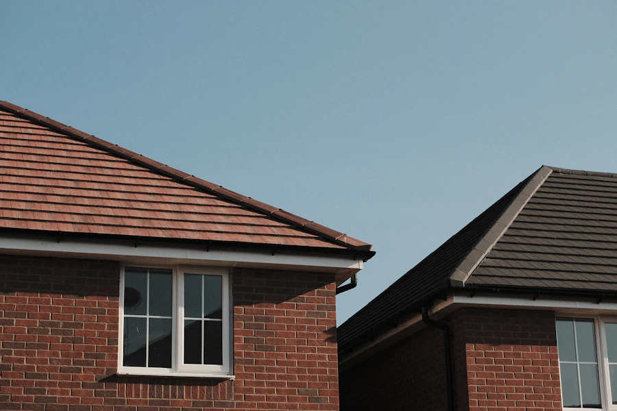 Brick houses with finished pitched roofs and clean eave lines against a pale sky
