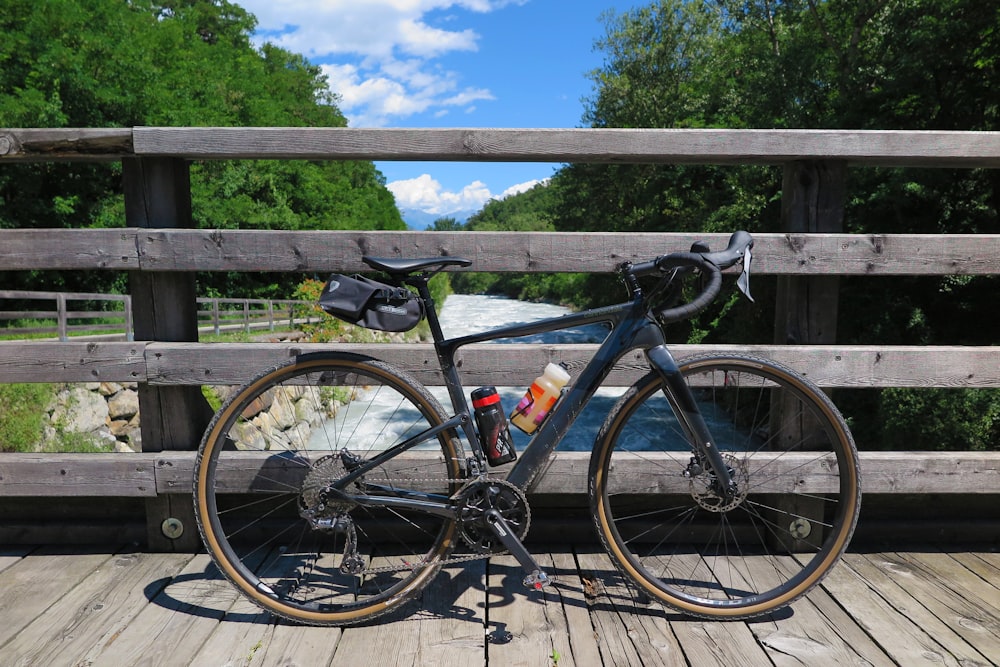 gravel bike leaning on brown wooden fence