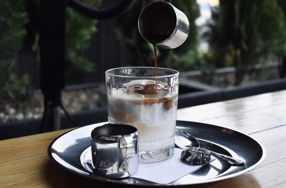 clear drinking glass on white ceramic plate