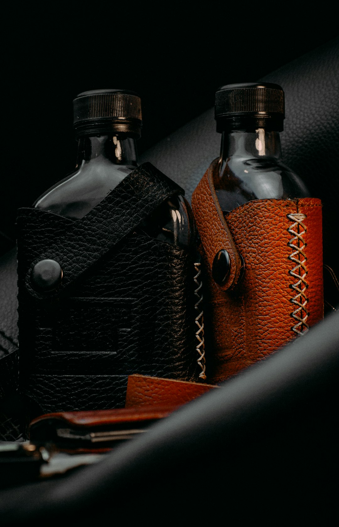 black and brown bottle on brown leather bag