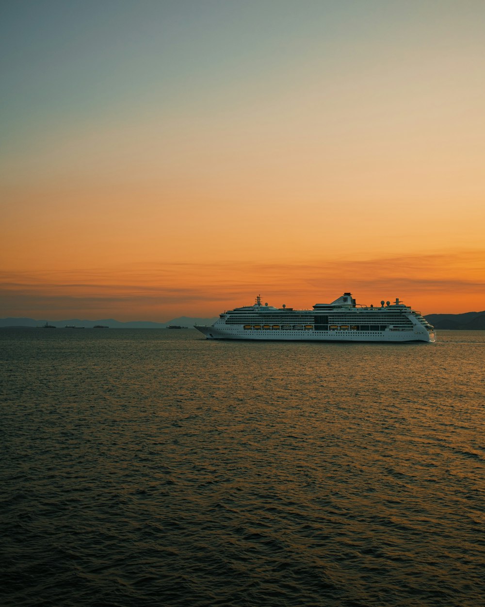 white cruise ship on sea during sunset