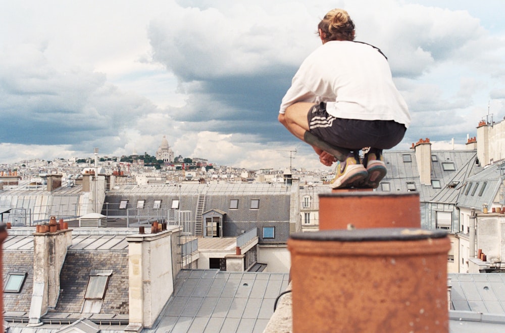 Man in white t-shirt and black pants sitting on brown concrete building  during daytime photo – Free Paris Image on Unsplash