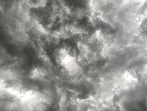 Dark and dense clouds swirl across the sky, creating a dramatic and moody atmosphere. The textures and patterns within the clouds suggest an impending storm or turbulent weather.