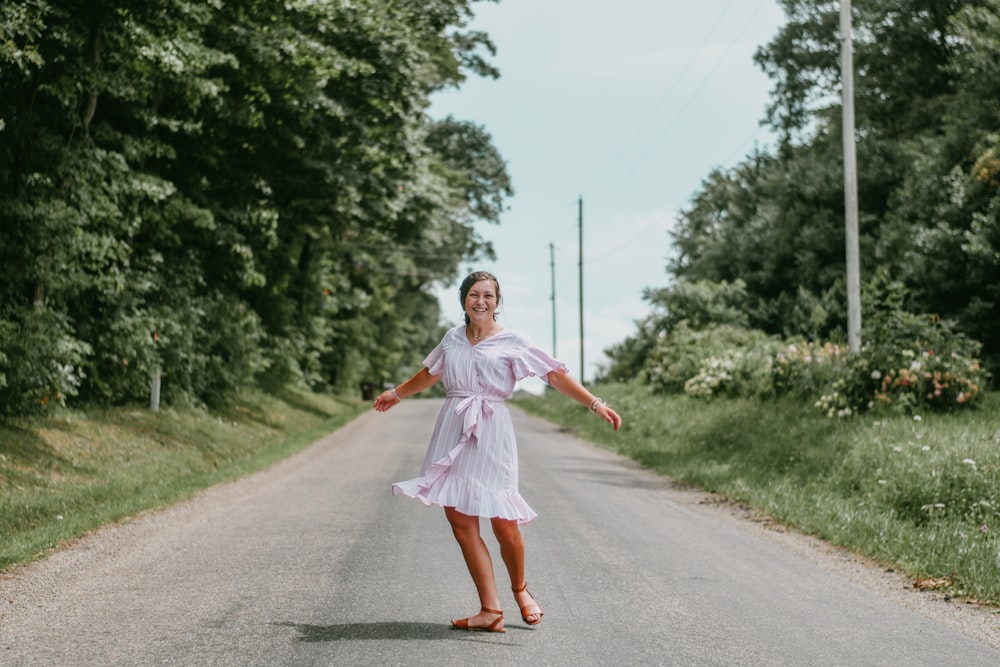 girl in pink dress running on road during daytime