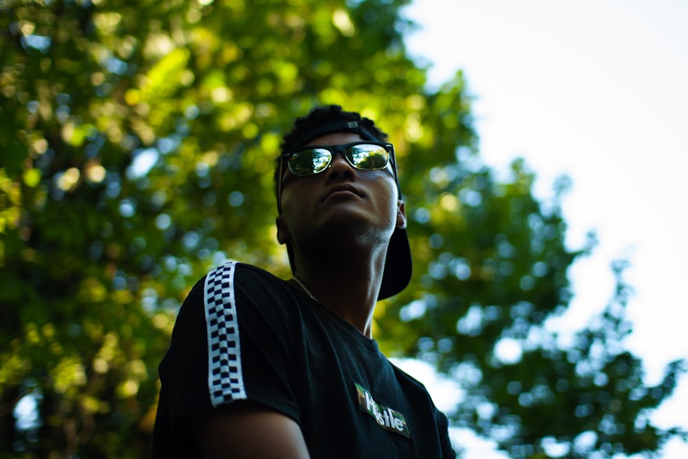 a man wearing sunglasses looking up into the sky