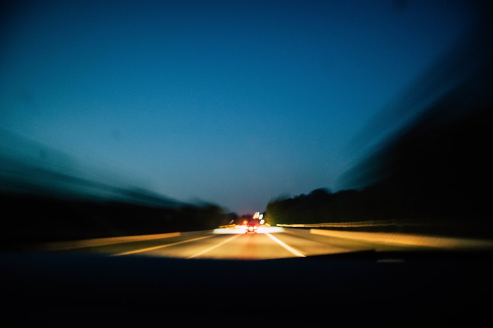 a blurry photo of a car driving down a highway
