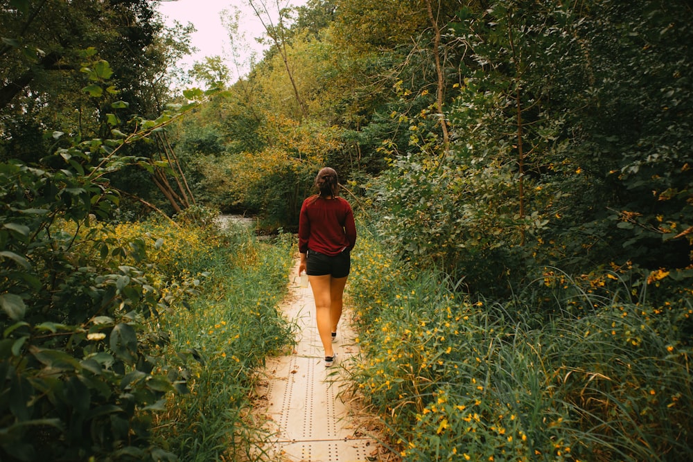 a woman walking down a path in the woods