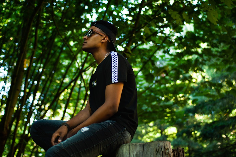 a man sitting on top of a tree stump